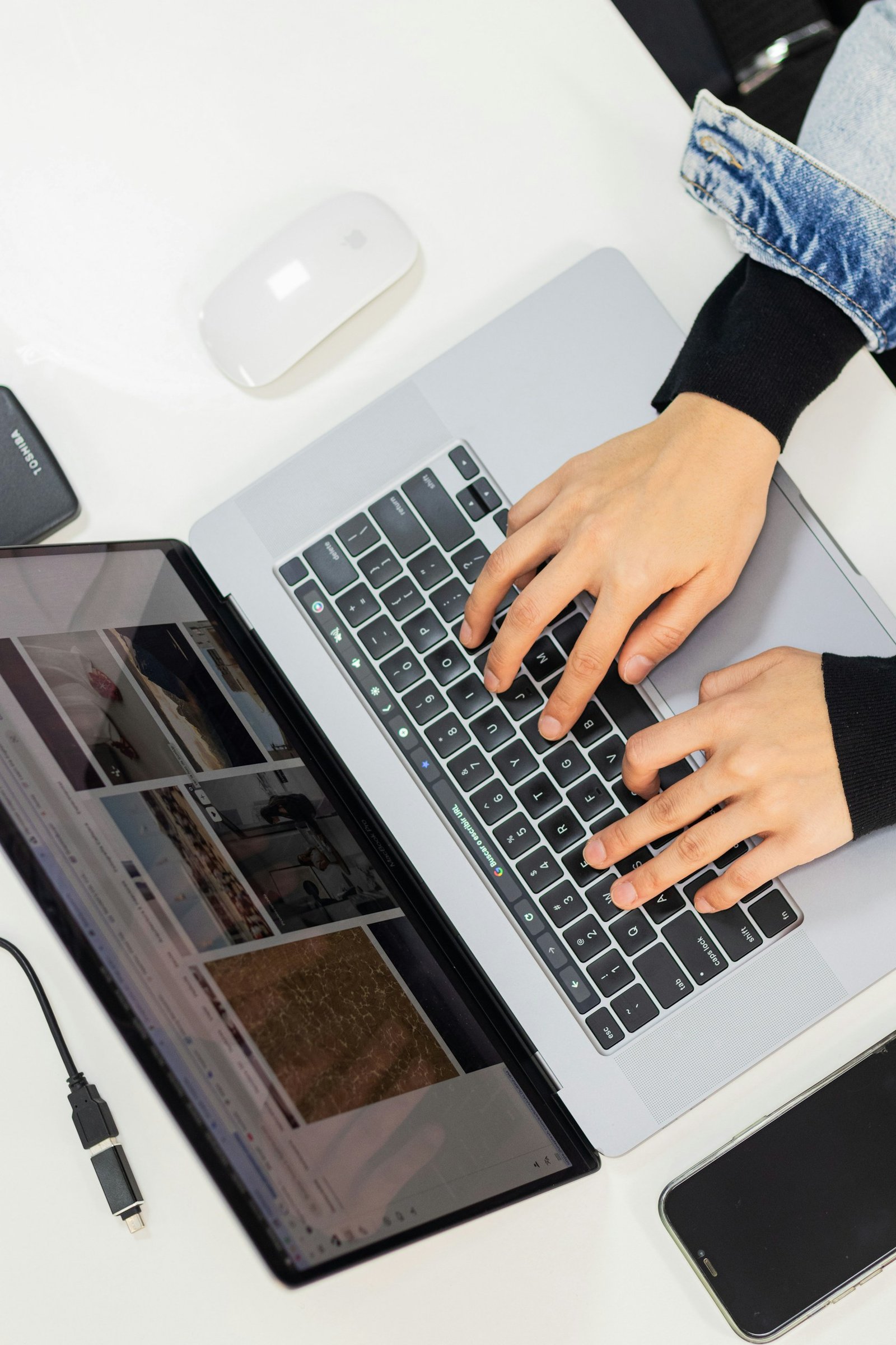 Hands using a laptop at a desk