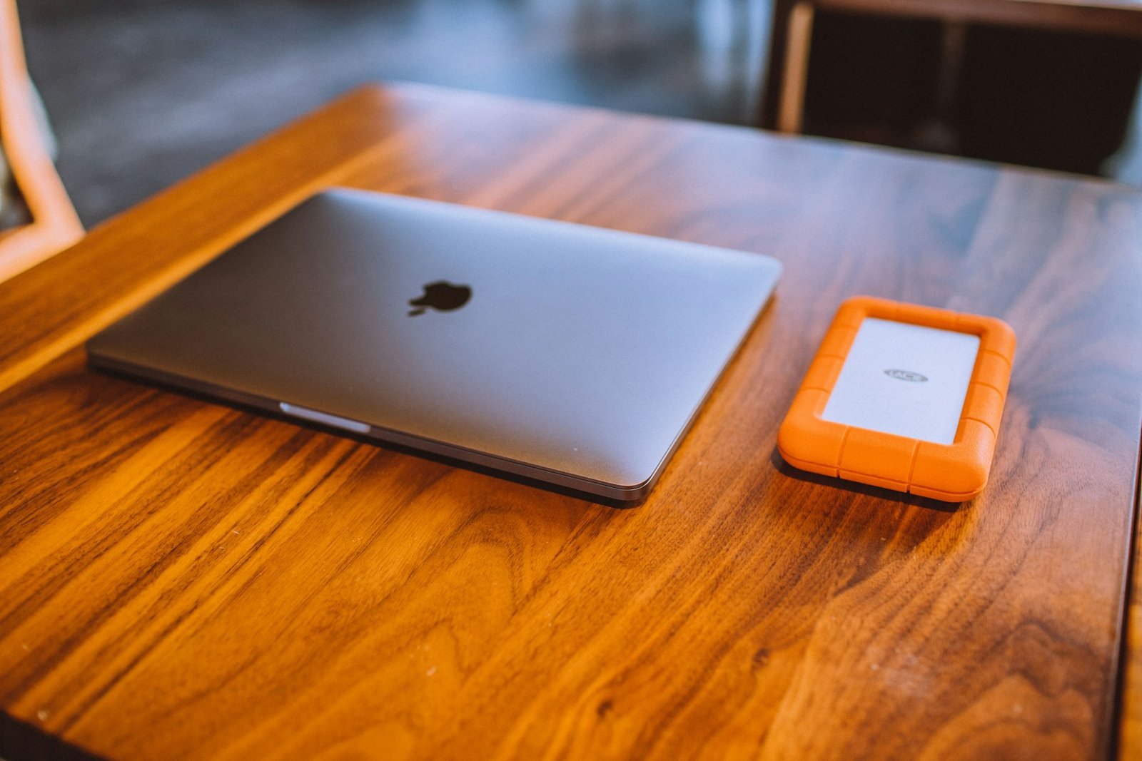 A laptop and portable storage on a wooden desk